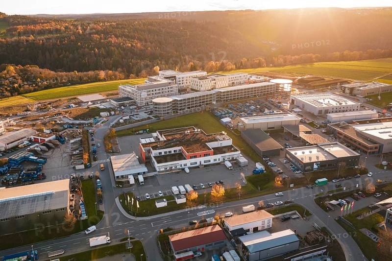 Large building complex with surrounding industrial areas in autumn landscape at sunset, new hospital, Calw health campus, Black Forest, Germany