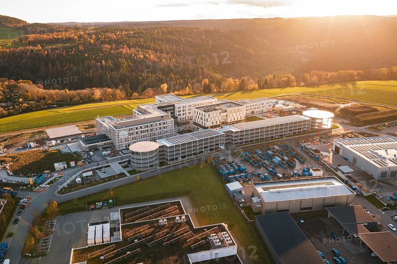 Aerial view of a large complex of buildings in autumn landscape at sunset, new hospital, Calw Health Campus, Black Forest, Germany
