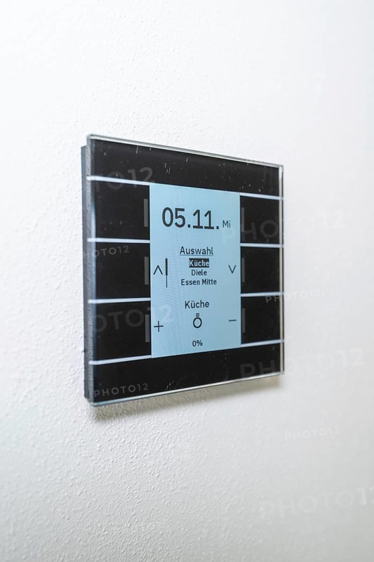 A modern switch on the wall with a blue display