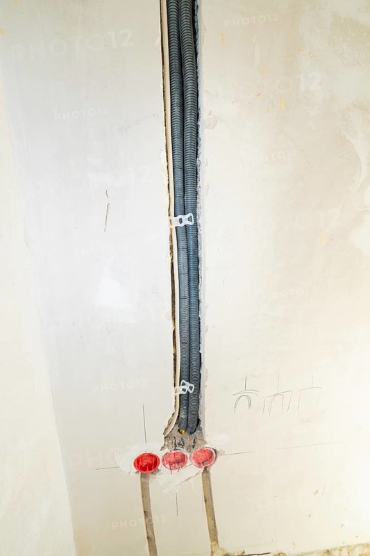 Black cable ducts inserted into the wall, prepared for electrical installation