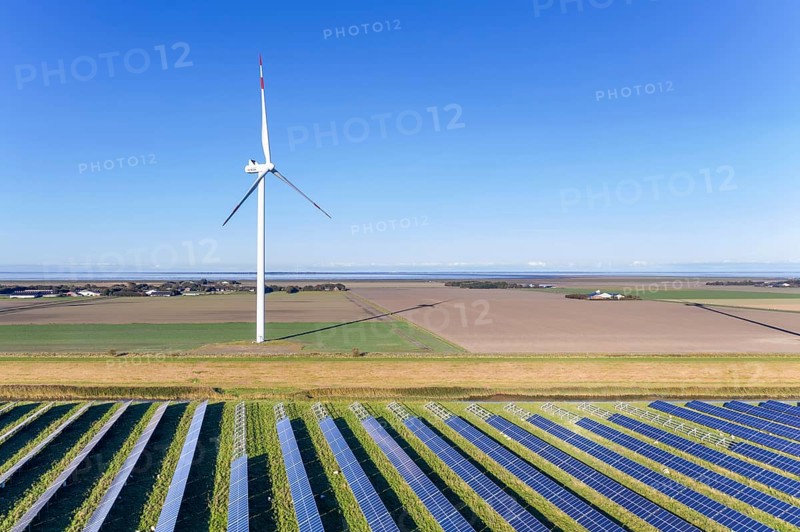 Aerial view over hybrid power plant combing solar photovoltaic modules and wind turbines, North Frisia, Schleswig-Holstein, Germany