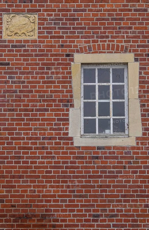 A rectangular window and a coat of arms in a red brick façade, Düstermühle, Münsterland, North Rhine-Westphalia, Germany