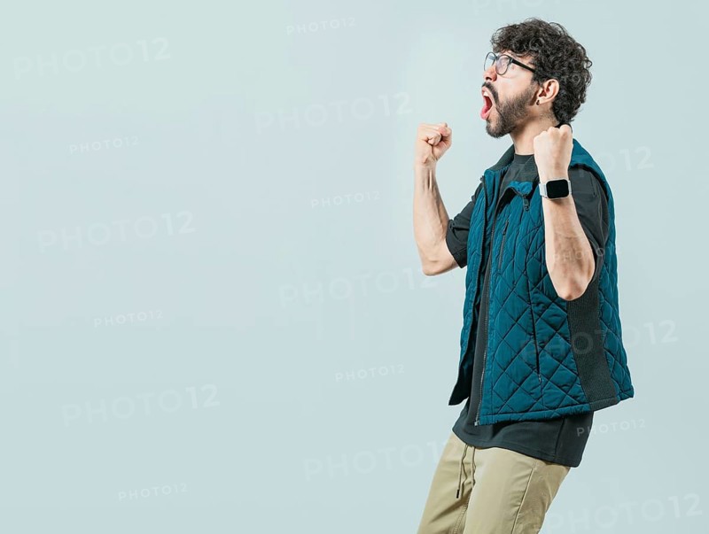 Happy guy with sunglass celebrating something. Excited young man celebrating looking at camera raising arms isolated