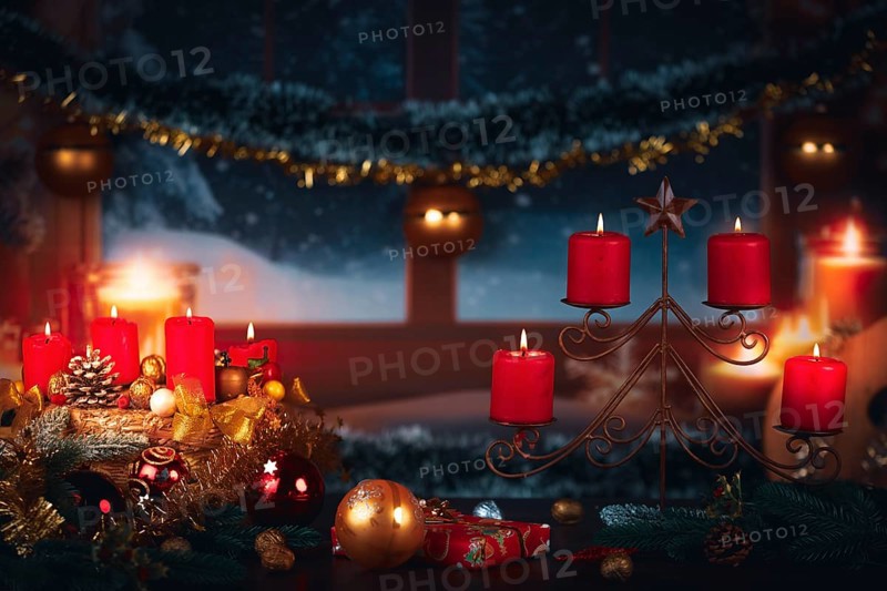 Festive Christmas decoration with red candles and gifts in front of a winter window