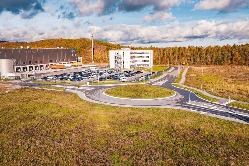 Building complex and roundabout in autumn landscape under blue sky, new Lindenrain industrial park, Calw, Black Forest, Germany