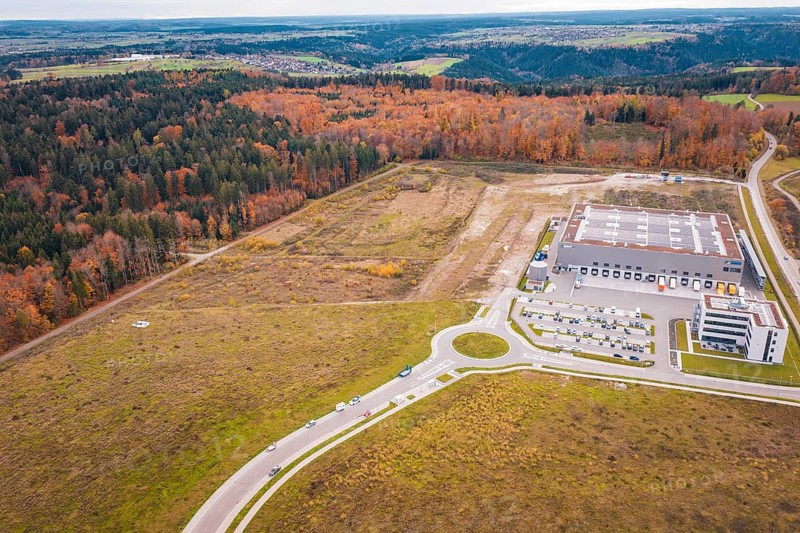 Industrial area with modern building on the edge of the forest and autumn landscape, new Lindenrain industrial park, Calw, Black Forest, Germany