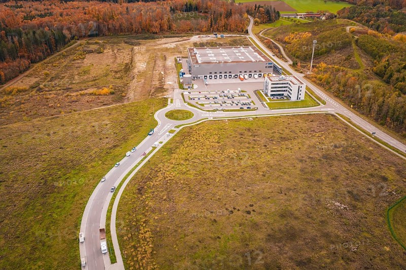 Industrial plant with surrounding roads and parking areas in an autumn landscape, new Lindenrain industrial park, Calw, Black Forest, Germany