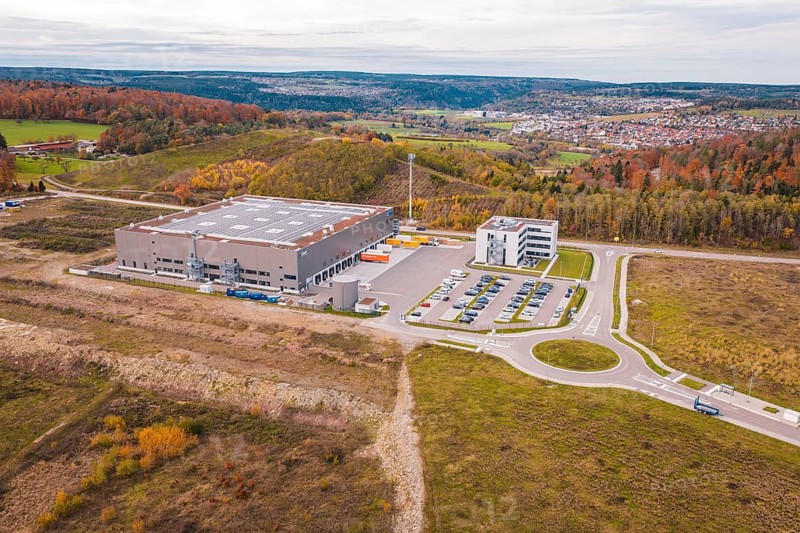 Industrial building with parking spaces in autumn hills, new Lindenrain industrial park, Calw, Black Forest, Germany
