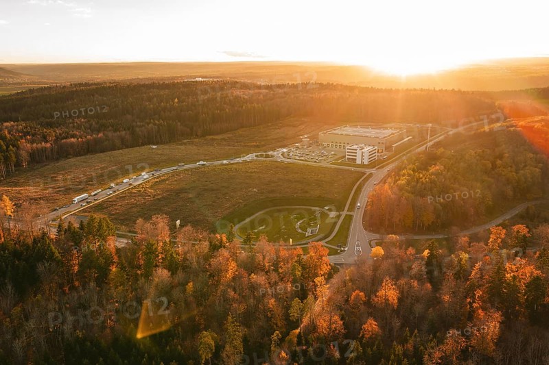 Sunset over a building in an autumn forest area with golden lighting, new Lindenrain industrial park, Calw, Black Forest, Germany