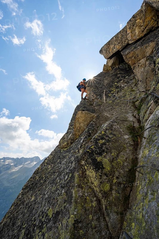 Female mountaineer on steep rock face on the secured via ferrata Krokodil-Bergsee am Bergseeschijen-Vorbau, Sonnenstern, Göscheneralp, Canton of Uri, Switzerland