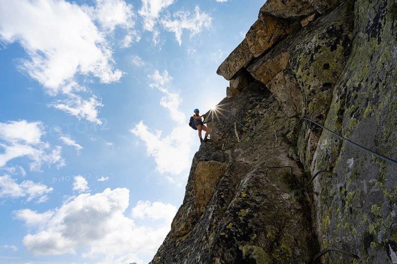 Female mountaineer on steep rock face on the secured via ferrata Krokodil-Bergsee am Bergseeschijen-Vorbau, Sonnenstern, Göscheneralp, Canton of Uri, Switzerland