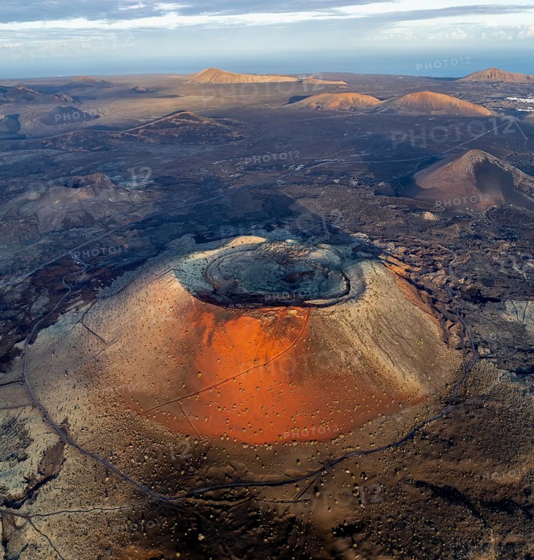 Caldera Colorada volcano, picturesque volcanic landscape with volcanic craters and lava fields in morning light, Parque Natural de Los Volcanes, aerial view, Lanzarote, Canary Islands, Spain