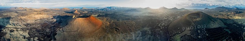 Panorama, Caldera Colorada volcano and Montaña Negra, picturesque volcanic landscape with volcanic craters and lava fields in morning light, Parque Natural de Los Volcanes, aerial view, Lanzarote, Canary Islands, Spain