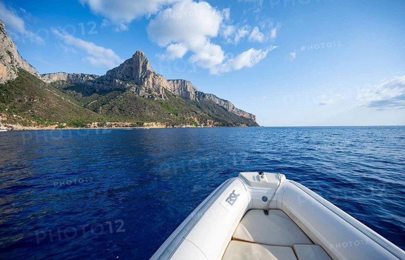 Motorboat trip along the picturesque rocky coast, cliffs and blue sea, Golfo di Orosei, Baunei, Sardinia, Italy