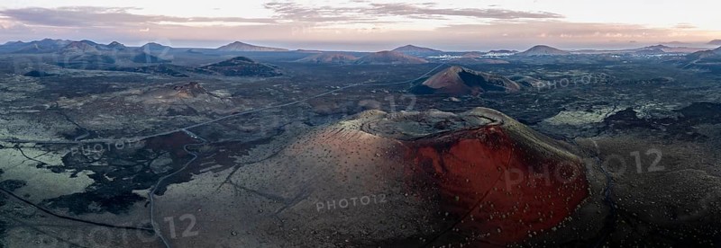 Caldera Colorada volcano, picturesque volcanic landscape with volcanic craters at sunrise, Los Volcanes Natural Park, aerial view, Lanzarote, Canary Islands, Spain
