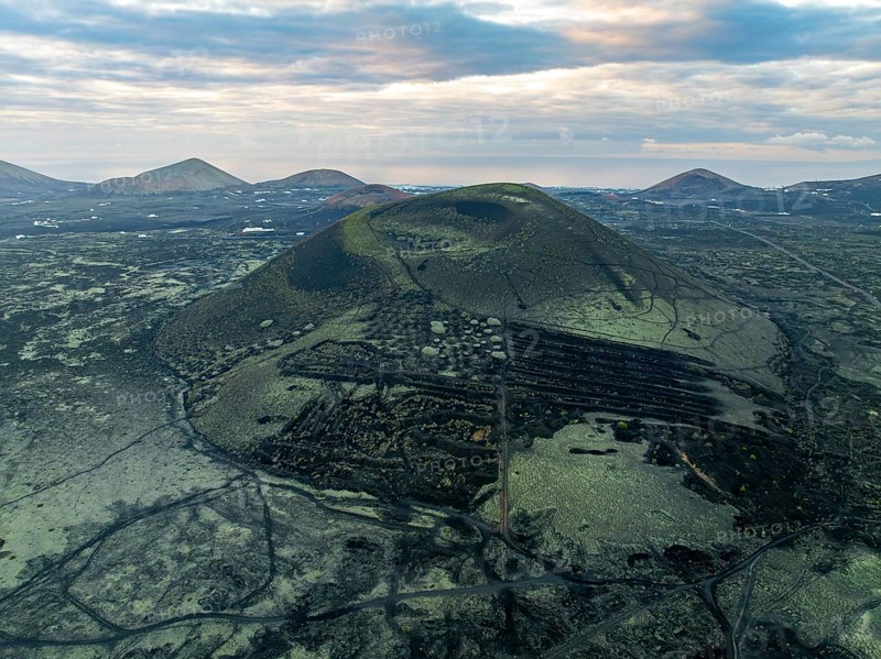 Montaña Negra volcano, picturesque volcanic landscape with volcanic crater at sunrise, Parque Natural de Los Volcanes, aerial view, Lanzarote, Canary Islands, Spain