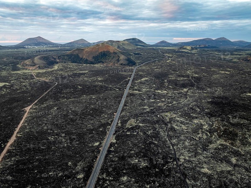 Road through lava fields, volcanic landscape with volcanic craters, Los Volcanes Natural Park, aerial view, Lanzarote, Canary Islands, Spain