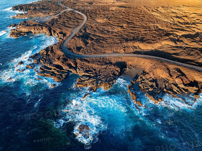 Road on the coast with lava fields, volcanic landscape near Los Hervideros, in the evening light, aerial view, Lanzarote, Canary Islands, Spain