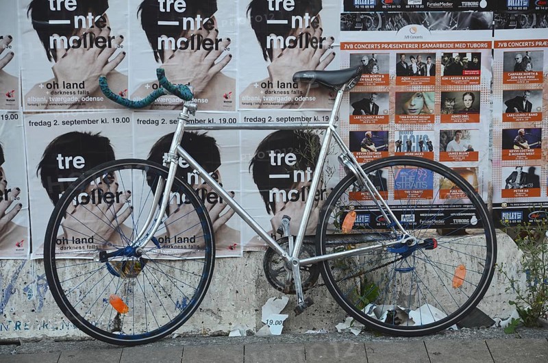 Racing bike set against a wall filled with posters in Odense, Fyn, Funen island, Denmark, Scandinavia