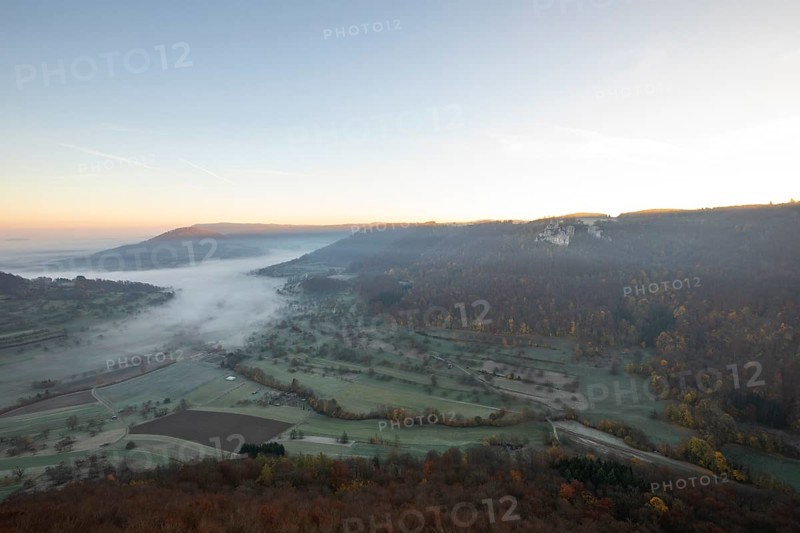Sunrise with fog in the Neidlinger Valley with a view of the Reussenstein castle ruins. Swabian Jura, Baden-Württemberg, Germany