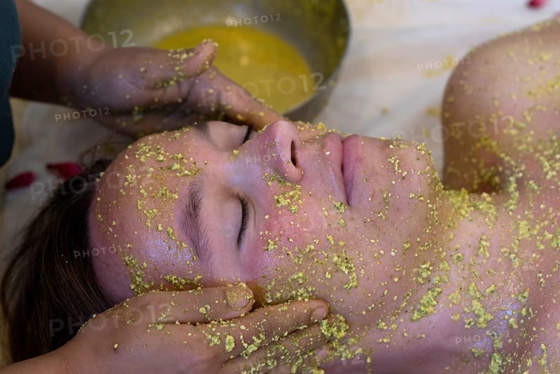 Person gets a relaxing facial massage with yellow Ayurvedic paste, Udaipur, Rajasthan, India