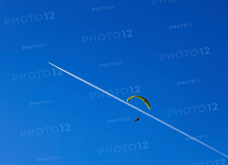 Paragliders with contrails in the blue sky, Osterhorn Group, Salzkammergut, Province of Salzburg, Austria