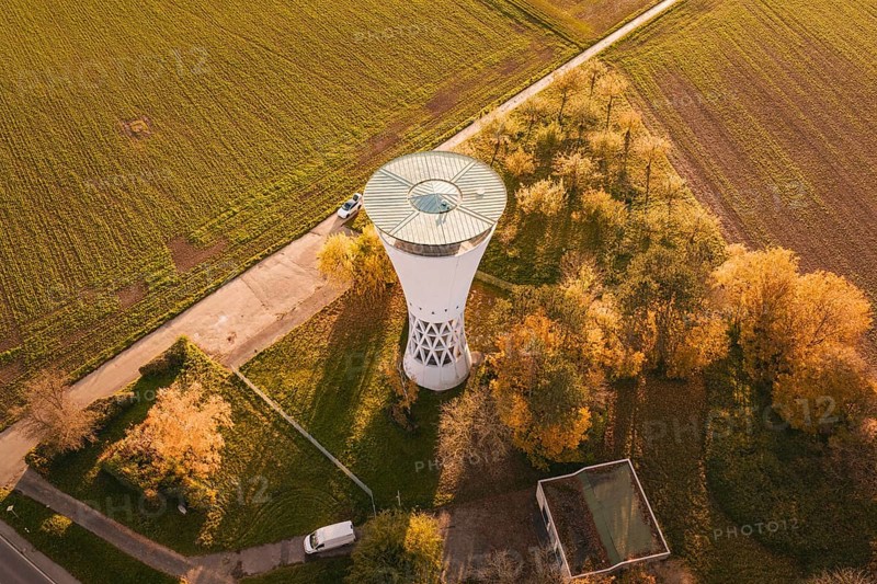 Water tower with surrounding autumn leaves, bordering fields in rural surroundings, Möglingen water tower, Germany