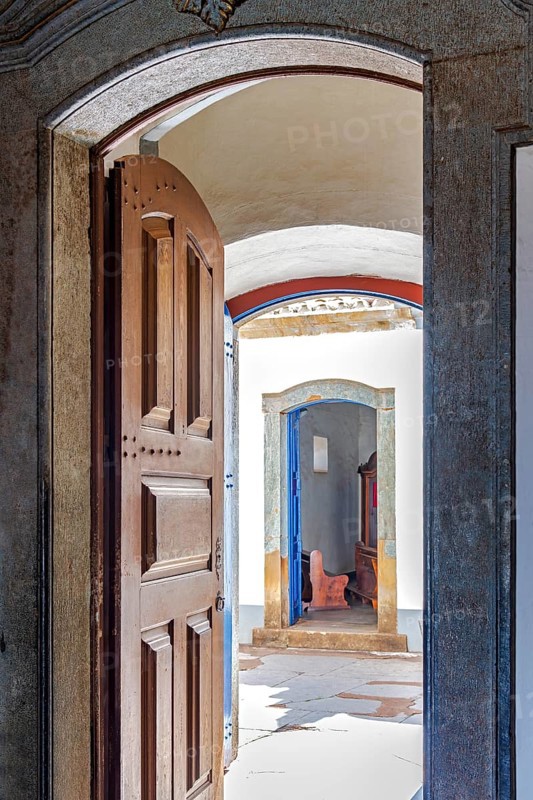 Open Baroque church door overlooking the courtyard and entrance to a chapel in Congonhas