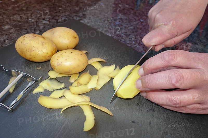 Southern German cuisine, preparing potatoes, cutting raw potatoes, peeling knife, kitchen knife, asparagus peeler, men's hands, cutting board, vegetarian, vegan, healthy, food photography, studio, Germany