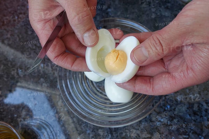 Southern German cuisine, preparation of aioli, garlic cream, mayonnaise, remove egg yolk from egg white, men's hands, food photography, studio, countertop, glass bowl, Germany