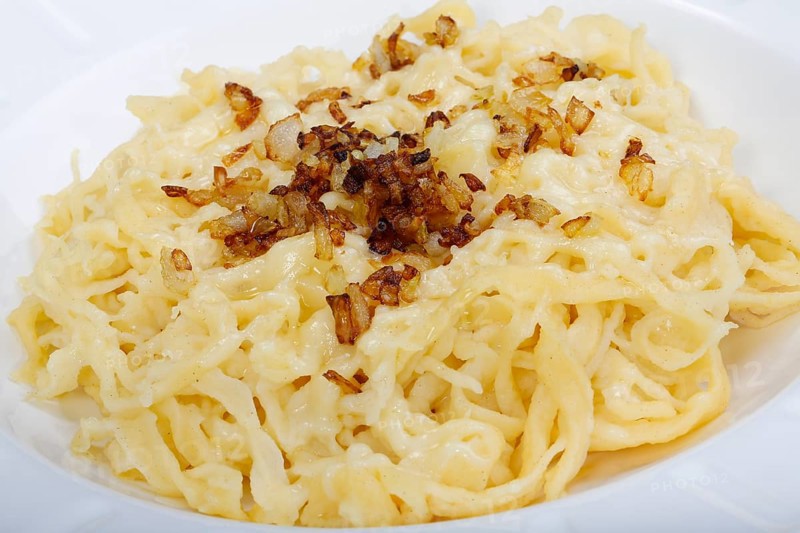 Swabian cuisine, cheese spaetzle, Swabian spaetzle baked with cheese, onion melt, hand-scraped spaetzle, served on plate, Swabian classic, typical Swabian, traditional cuisine, grandma's kitchen, pastry, vegetarian, food photography, studio, Germany