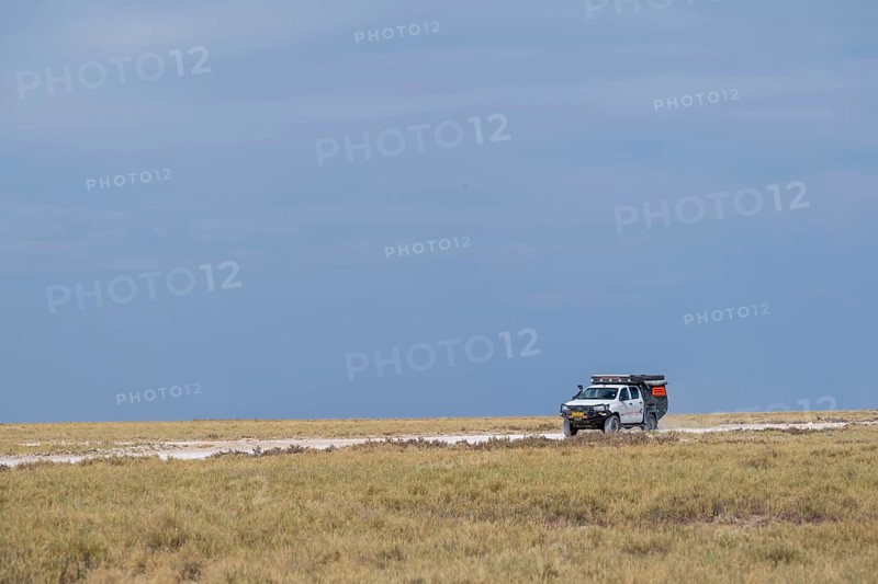 Safari car drives through steppe, Etosha National Park, Namibia