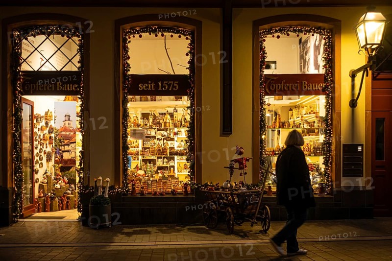 At Christmas time, a passerby strolls through Frankfurt's New Old Town and looks at the shop windows of a souvenir shop, Neue Altstadt, Frankfurt am Main, Hesse, Germany