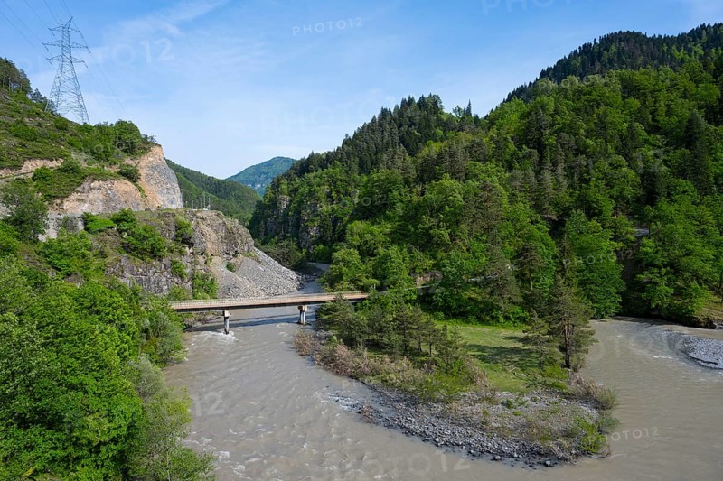 A wide river flows under a bridge through wooded hills while a power line crosses the rocky landscape, landscape near Kldisubani, Adjaristskali River, Adjara, Adjaria, Lesser Caucasus, Georgia