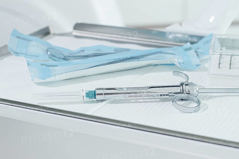 A carpal syringe, reusable, for use in dentistry, for the administration of anesthetic, lies on the table