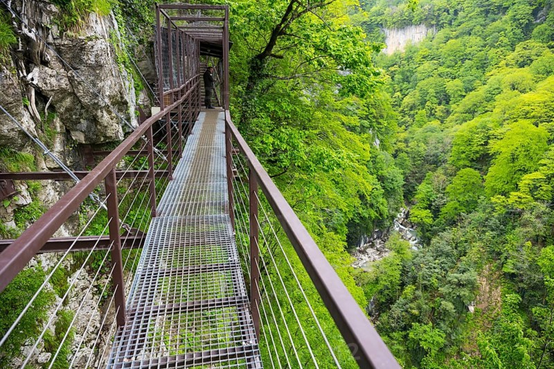 Metal footbridge leads through a green forest gorge, Okatse gorge, canyon, Imereti region, Imereti, Georgia