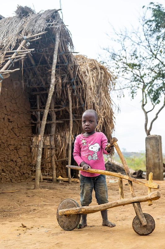 Child playing with a self-made wooden balance bike, in a Sadaani village, Tanga, Tanzania