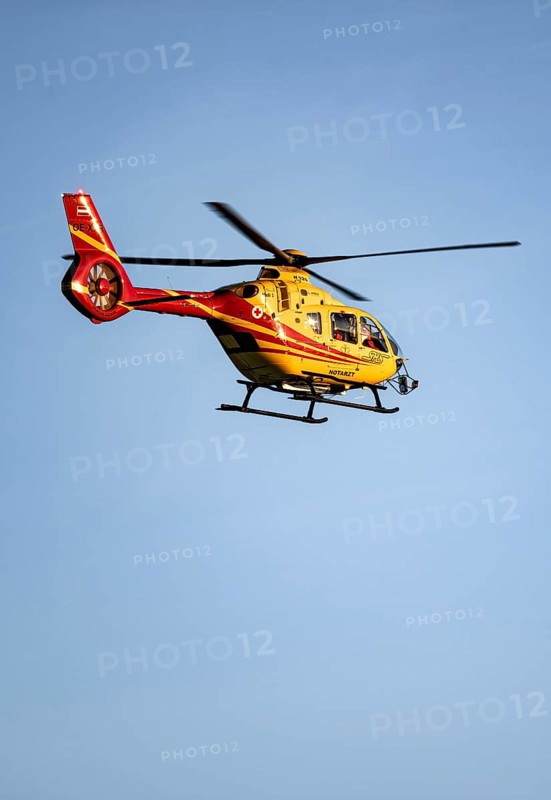 Rescue helicopter flying against a blue sky, Tyrol, Austria