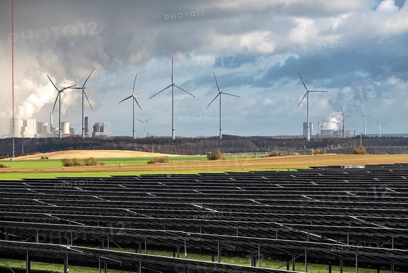 86.5 MW peak open space photovoltaic systems, from RWE, with over 141, 000 solar modules, on a side strip, along the A44 motorway near Jüchen, at the timber triangle, recultivated open-cast mining area, in the background RWE Neurath lignite power plant and on the right the Niederaußem power plant, wind farm, North Rhine-Westphalia, Germany