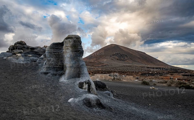 Eroded rock formations, volcanic landscape with dramatic cloudy skies, Ciudad Estratificada or Los Roferos, Antigua Rofera de Teseguite, Lanzarote, Canary Islands, Spain