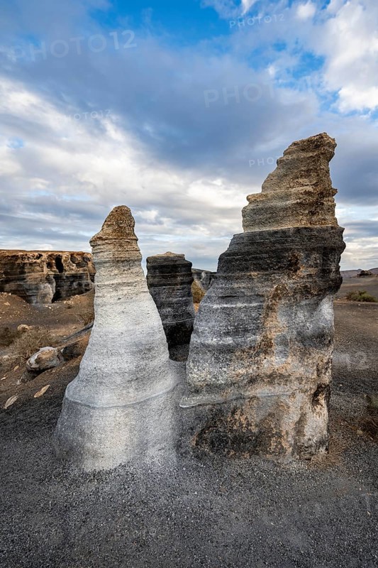 Eroded rock formations, volcanic landscape with dramatic cloudy skies, Ciudad Estratificada or Los Roferos, Antigua Rofera de Teseguite, Lanzarote, Canary Islands, Spain