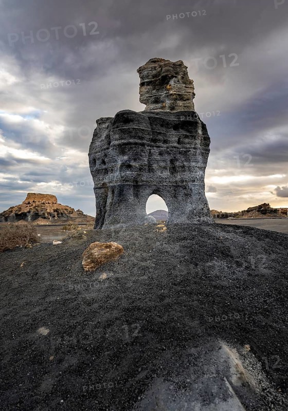 Eroded rock formations with rock tunnels, volcanic landscape with dramatic cloudy skies, Ciudad Estratificada or Los Roferos, Antigua Rofera de Teseguite, Lanzarote, Canary Islands, Spain
