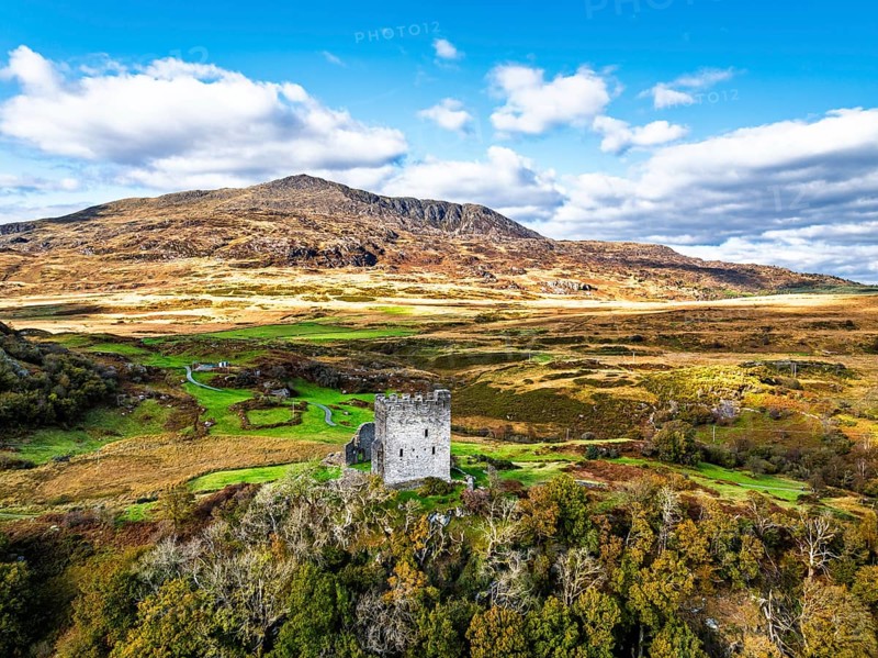Autumn colours over Castell Dolwyddelan and Eryri Mountains from a drone, Snowdonia, Conwy County Borough, Wales, England, United Kingdom