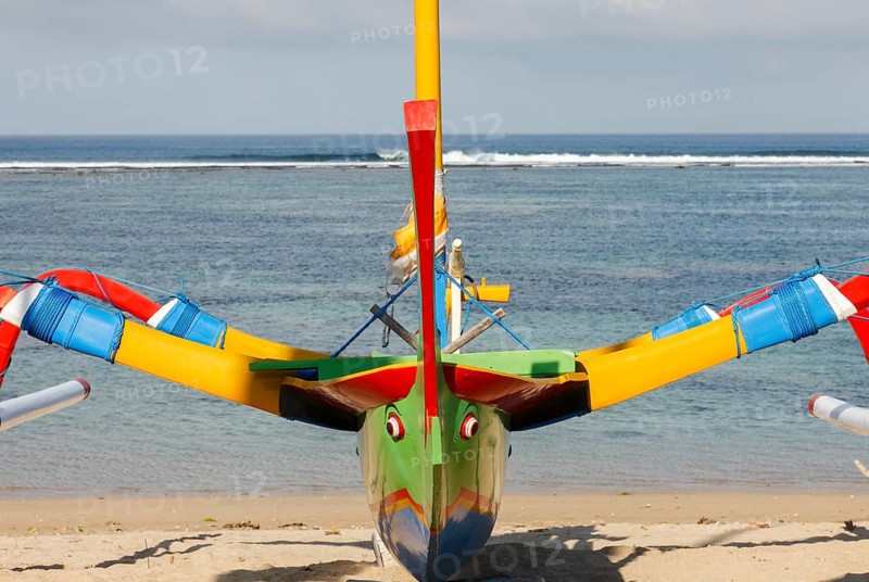 Colourfully painted outrigger fishing boats, (Junkung), on Sanur beach, Bali, Indonesia