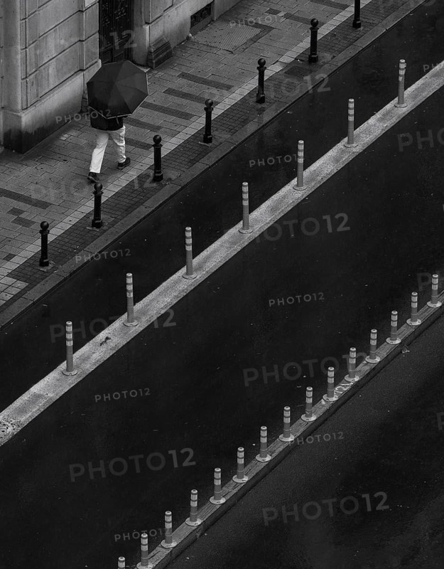 Man with umbrella walking on a street, from above, monochrome, street scene, Belgrade, Serbia