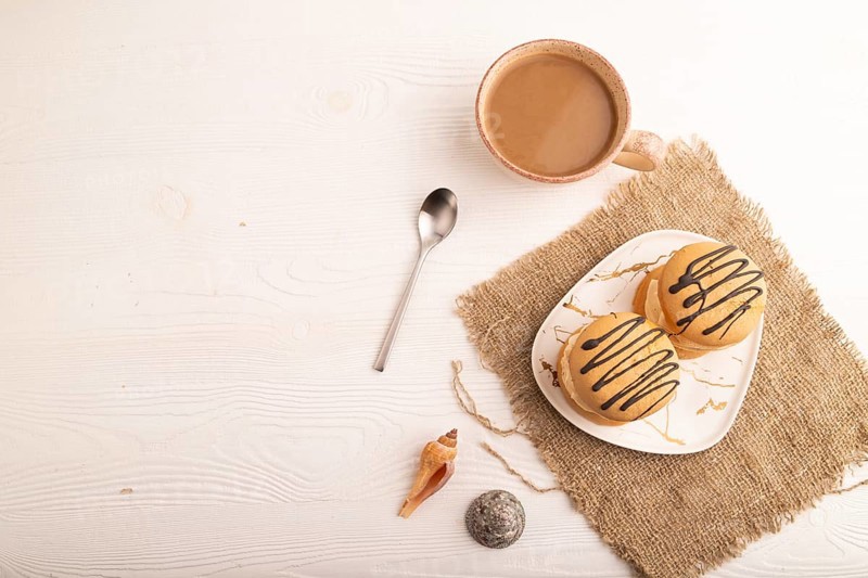 Caramel Cream Cakes on white wooden background and linen textile, cup of coffee, top view, flat lay, copy space