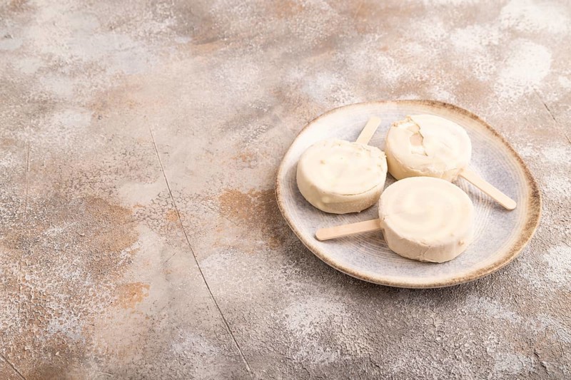 ?hocolate Ice cream in white glaze, on brown concrete background, side view, copy space, minimalism