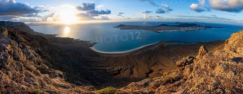 View of steep cliffs to sea and the island of La Graciosa, Mirador del Porrito viewpoint at sunset, Lanzarote, Canary Islands, Spain