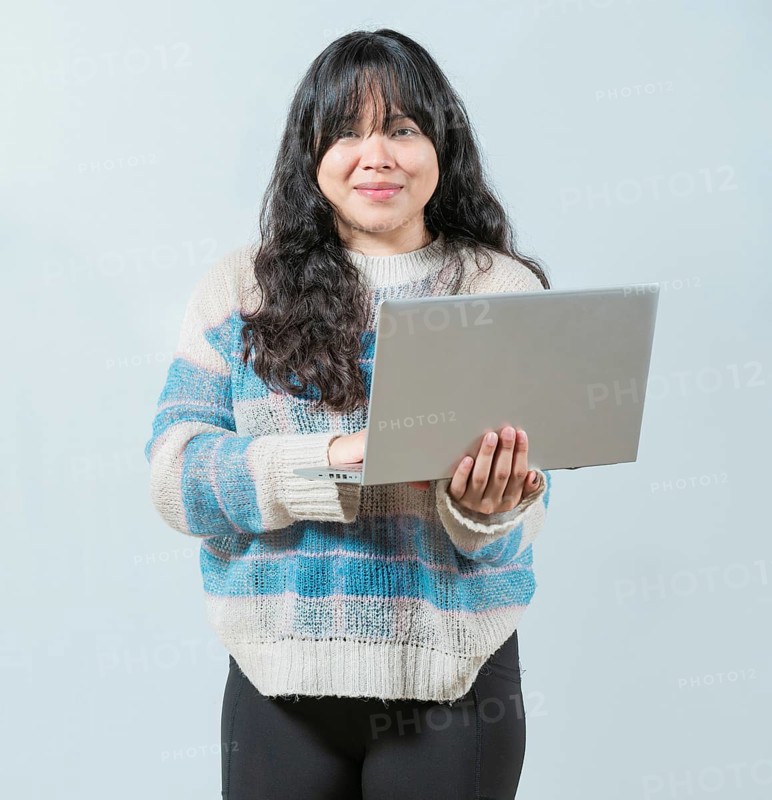 Beautiful asian girl using laptop and looking at camera isolated. Smiling asian woman using notebook and looking at camera