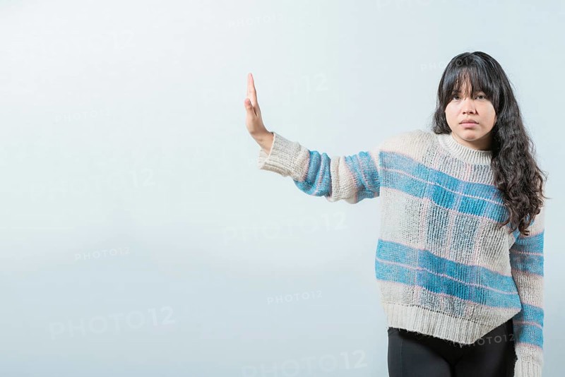 Asian girl making rejection gesture with palm of hand isolated. Displeased asian woman rejecting with palm hand